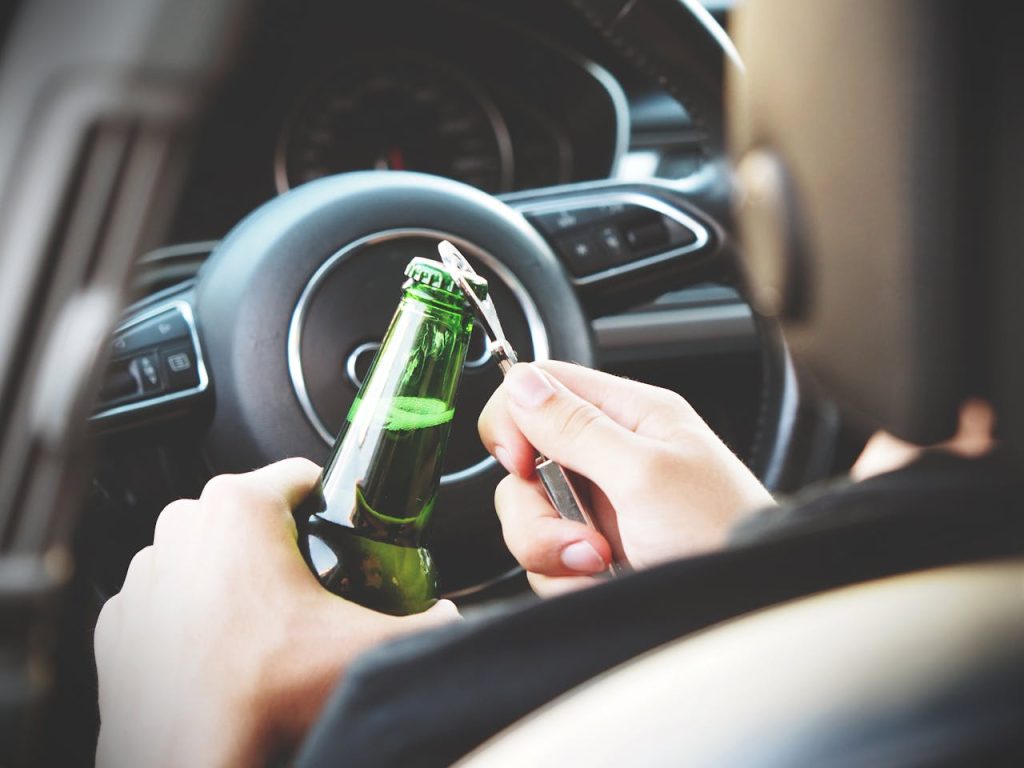 Flesje bier alcohol openen achter stuur auto